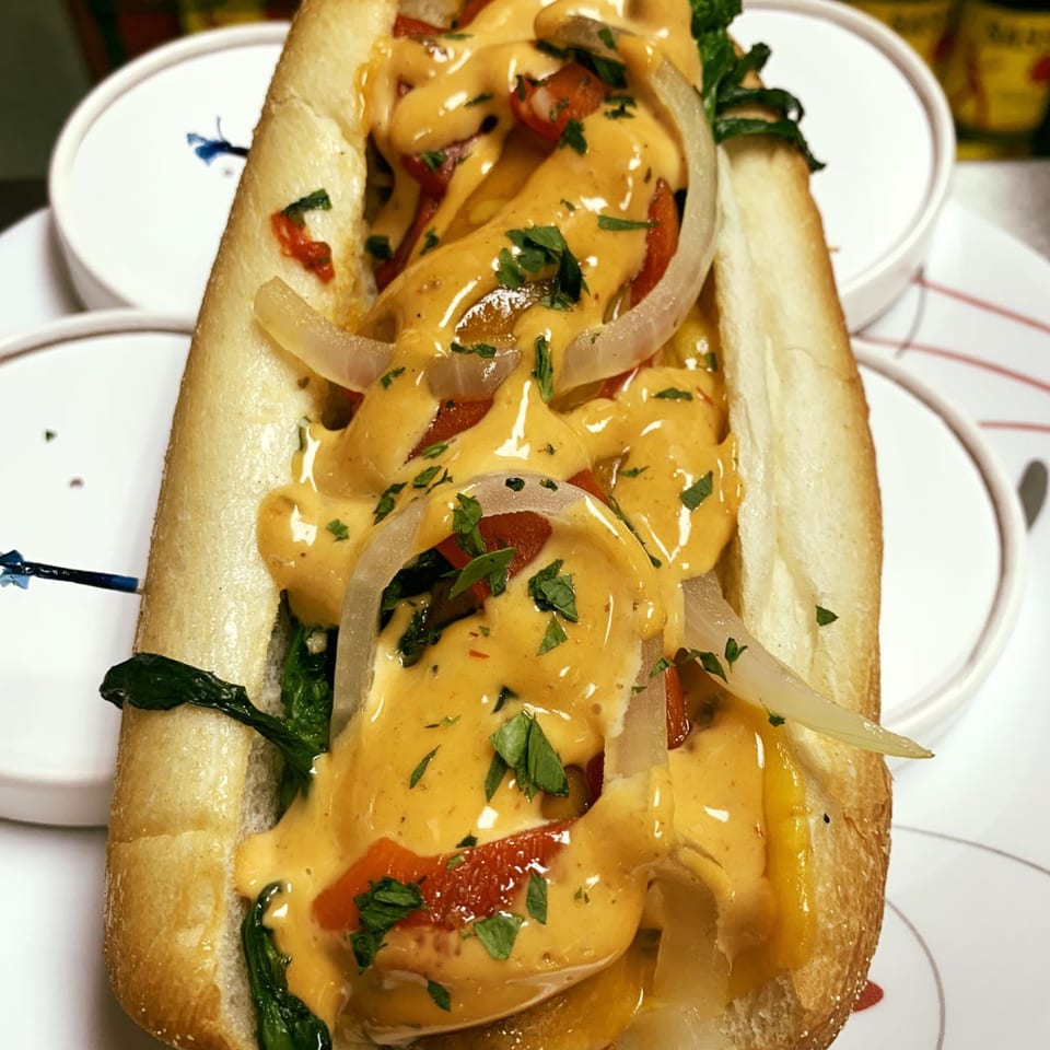 A Parma Market & Bakery deli sandwich, generously topped with melted cheese, onions, peppers, and greens.